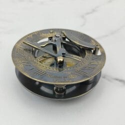 Side profile of the black brass sundial compass, highlighting the antique finish and solid construction.