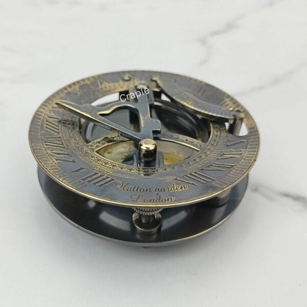 Side profile of the black brass sundial compass, highlighting the antique finish and solid construction.