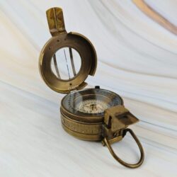 Open brass prismatic compass highlighting the lid with its sighting line and the folding prism for taking bearings.