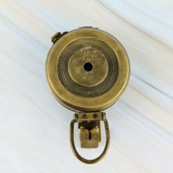 The bottom of the brass WWII prismatic compass, showing the concentric ring design and authentic engravings.