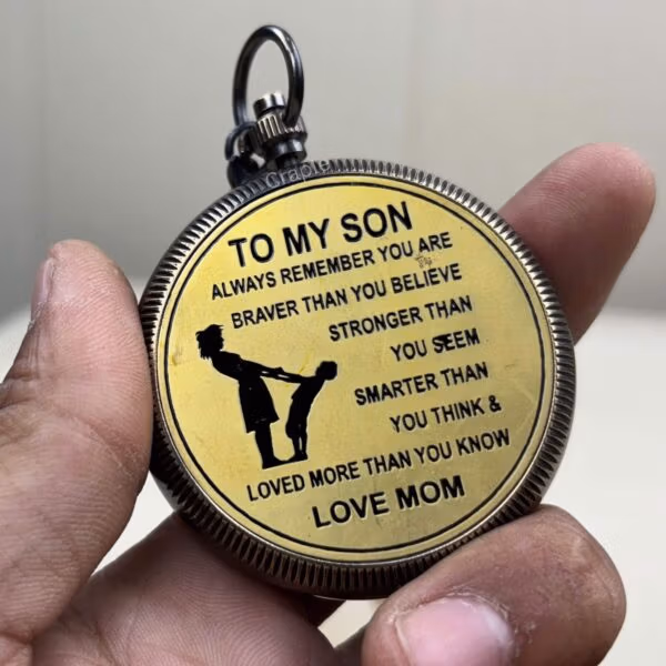 Close-up of the back of a brass compass showing the engraved message "To My Son... Love Mom".