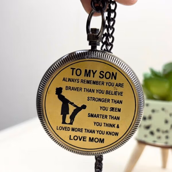 The back of the "To My Son" pocket compass with its heartfelt engraved message and attached chain.