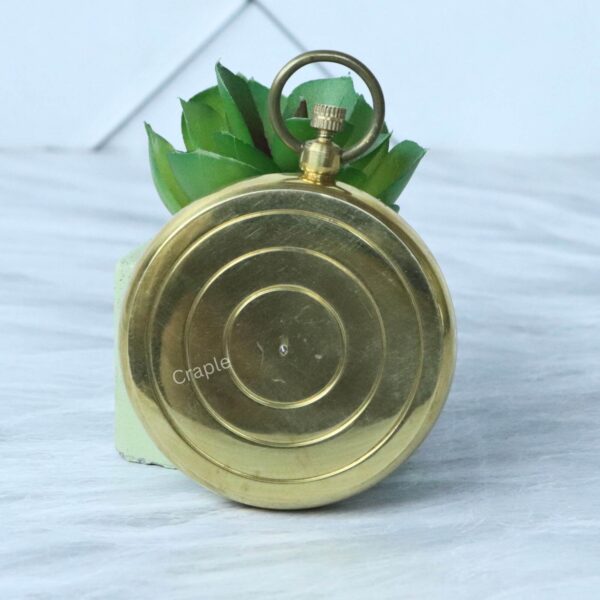 Classic Open Face Pocket Compass-2 The back of the polished brass pocket compass, showing its smooth surface with concentric circle details.