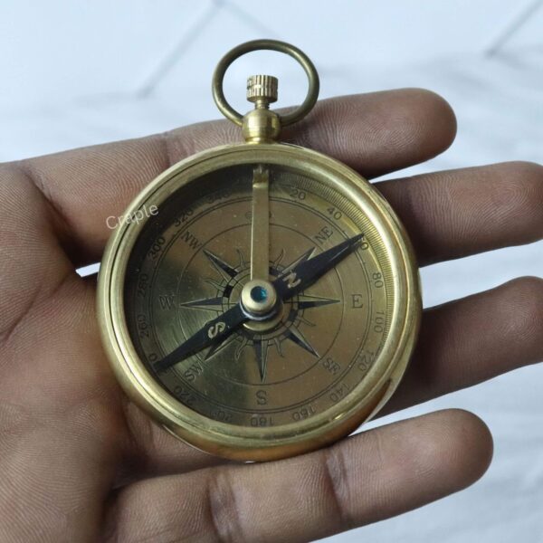 Classic Open Face Pocket Compass-4 The solid brass pocket compass held in a person's hand to show its portable, pocket-friendly size.