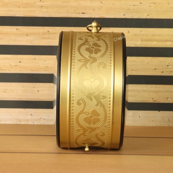 Close-up of the ornate, embossed floral pattern on the golden casing of the double-sided station clock.