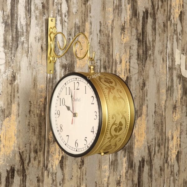 Vintage double-sided station clock with a golden finish, mounted on its decorative wall bracket.