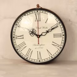 Close-up of a vintage station clock face with classic Roman numerals and ornate black hands.