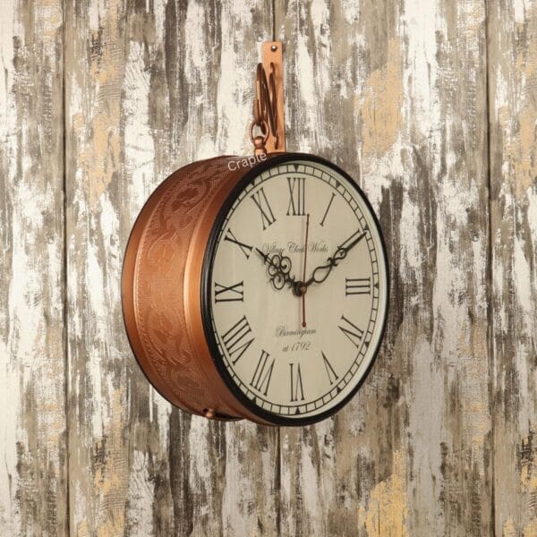 Side view of the hanging double-sided wall clock, showing its classic face and embossed brass-coated frame.