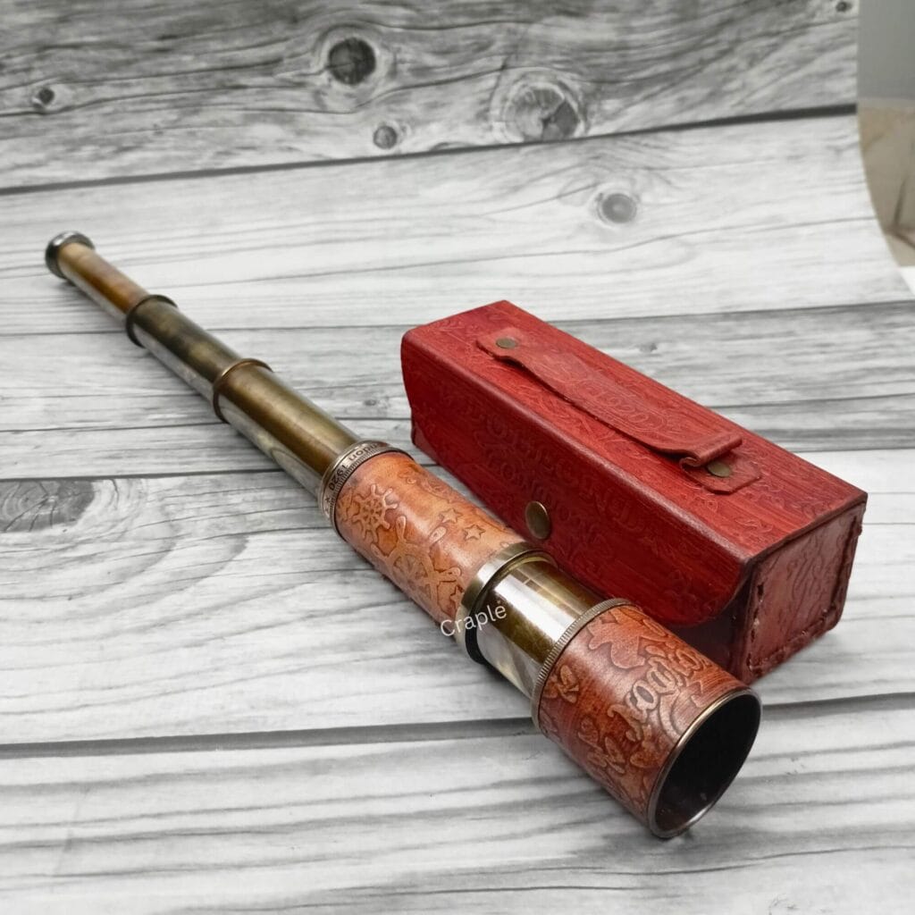 Fully extended Dollond London brass spyglass with an embossed leather grip, displayed next to its matching red leather case.