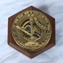 Polished brass F.L. West London sundial compass presented on a handsome hexagonal wooden display base.