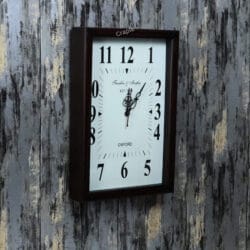 Vintage-style rectangular wall clock in a teak-polished wooden frame, shown at an angle to display its depth.