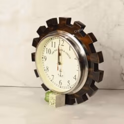 Angled view of the gear-shaped clock standing on a surface, highlighting its antique brown-black finish.