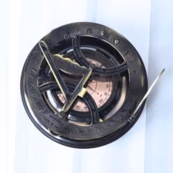 Top-down view of the Gilbert & Sons sundial, showing the internal compass with cardinal points and needle.