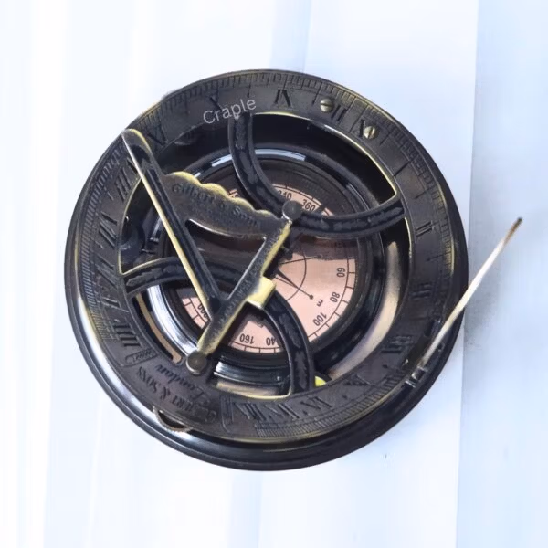 Top-down view of the Gilbert & Sons sundial, showing the internal compass with cardinal points and needle.