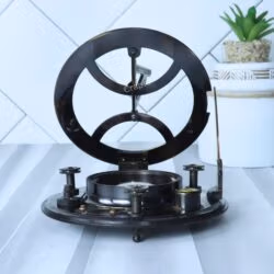 Side profile of the black antique brass sundial compass with the gnomon folded flat and adjustable leg screws visible.