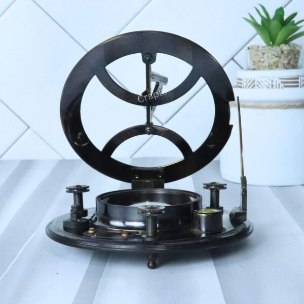 Side profile of the black antique brass sundial compass with the gnomon folded flat and adjustable leg screws visible.