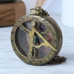 Angled view of the vintage-style brass pocket sundial, highlighting its pocket watch design and attached chain.