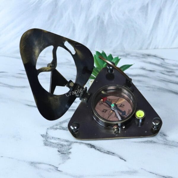 The triangular sundial compass opened to reveal the functional magnetic compass, needle, and integrated bubble level.