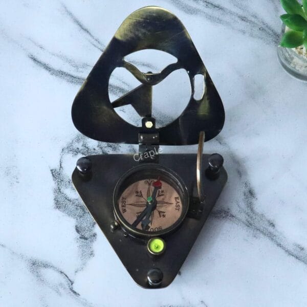 Overhead view of the open triangular compass, showing the north, south, east, and west markings and the bubble level.