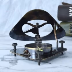 Three-quarter view of the Gilbert & Sons triangular compass in its open position, with the sundial lid acting as a stand.