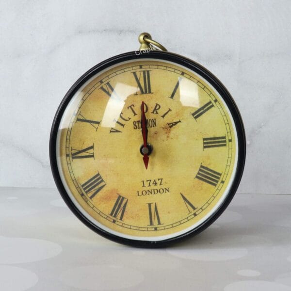 Close-up of the antique-style face of a Victoria Station wall clock with Roman numerals.