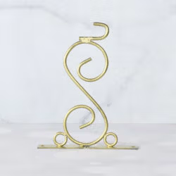 The ornate scroll wall bracket for the double-sided station clock, featuring a golden finish.