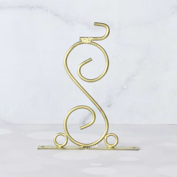 The ornate scroll wall bracket for the double-sided station clock, featuring a golden finish.