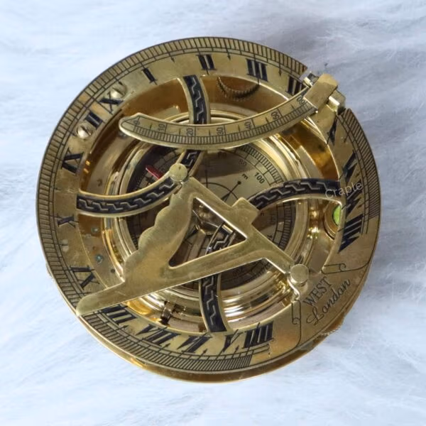 Top-down view of a handcrafted brass sundial compass with Roman numerals and intricate astronomical details.
