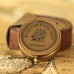The bottom of the antique brass sundial compass with an engraving that reads "Made for Royal Navy London".