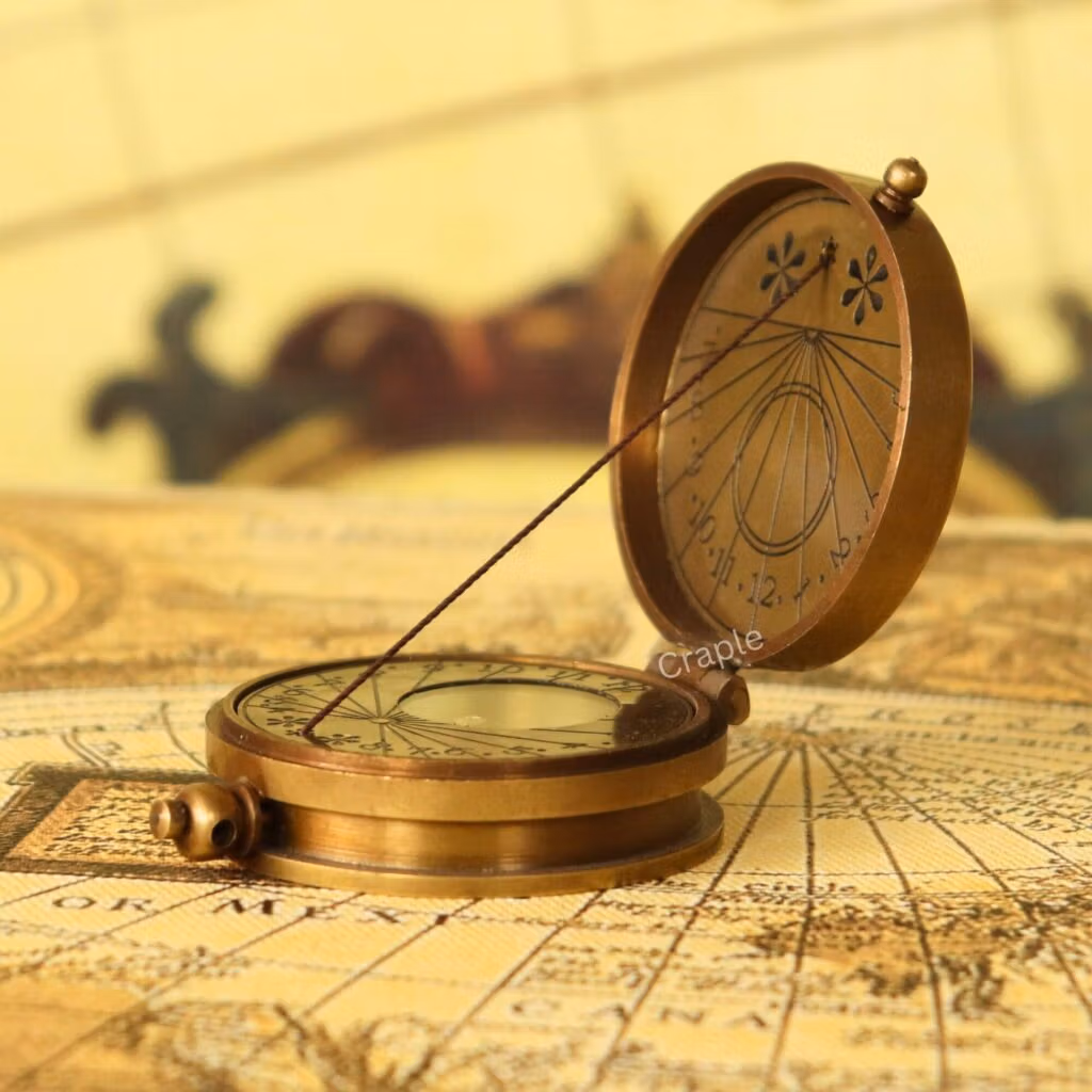 An antique-finish brass dori sundial compass, opened to show the internal compass and string gnomon sundial.