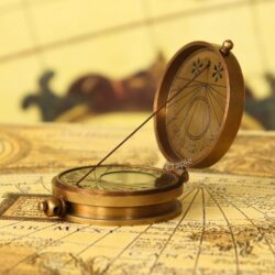 An antique-finish brass dori sundial compass, opened to show the internal compass and string gnomon sundial.