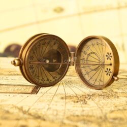 Angled view of the open pocket sundial compass, displaying both the sundial face and the magnetic compass.