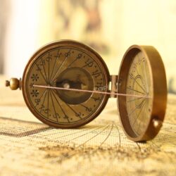 The Royal Navy style sundial compass opened fully to show the two internal faces of the sundial and compass.