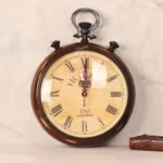 Vintage stopwatch-style wall clock with a brown antique wooden frame and an aged dial with Roman numerals.