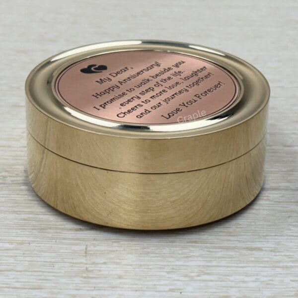 Closed brass pocket compass with a brushed finish, featuring a "Happy Anniversary" message engraved on the lid.