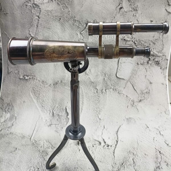 Front view of a vintage Kelvin & Hughes double-barrel telescope with an antique brass finish on a tripod stand.