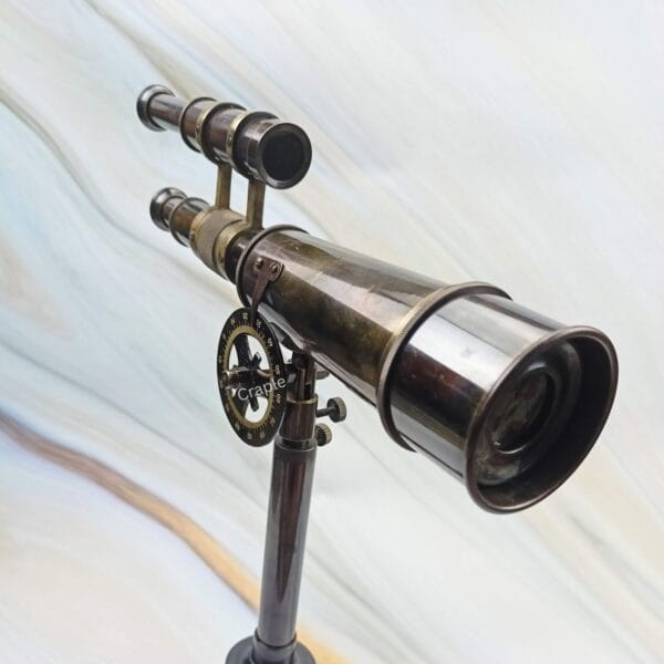 Close-up of the objective lens and brass body of the Kelvin & Hughes double-barrel telescope.