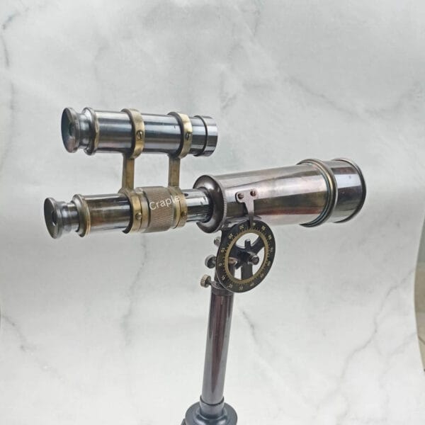 High-angle view of the double-barrel brass telescope on its stand, displaying its classic form.