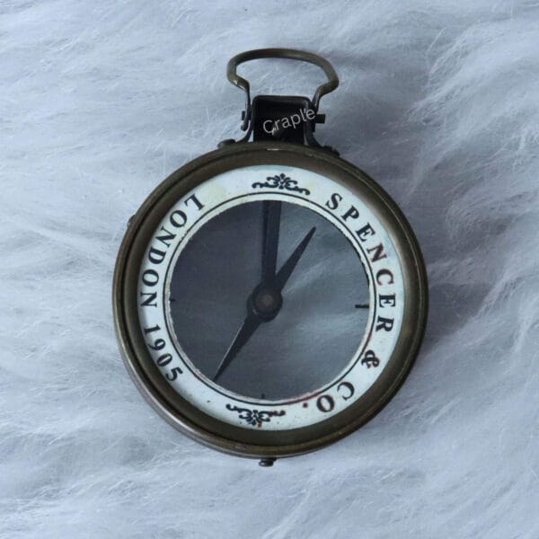 Top-down view of the Spencer & Co. London 1905 map reader compass on a white background.