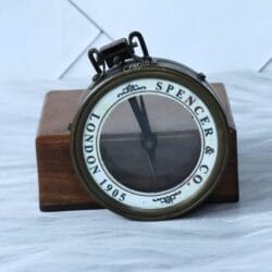 Close-up of the lever mechanism used to lift the magnifying glass on the antique brass compass.
