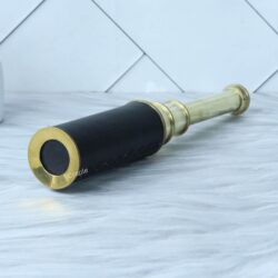 Vintage brass and leather spyglass, partially extended to show the polished brass barrels.