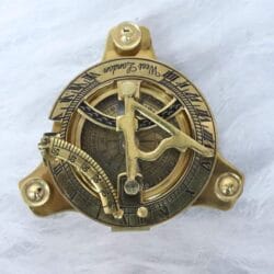 Top-down view of a vintage West London sundial compass made from polished brass.