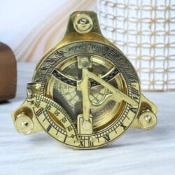 Angled view of the nautical brass sundial compass showing the adjustable latitude scale.