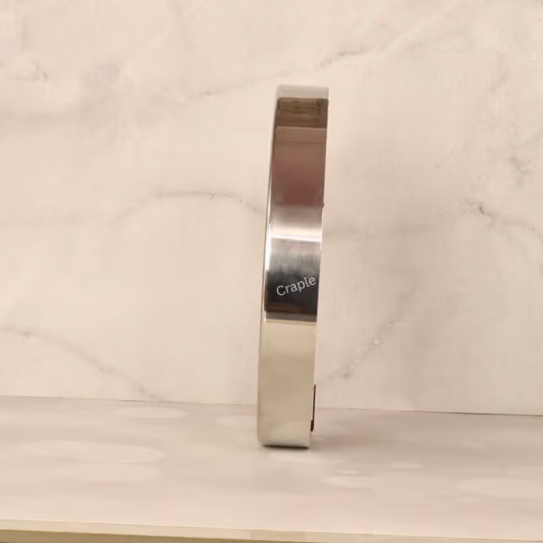 Side profile of the industrial-style steel wall clock, showing the depth and reflective silver polish finish.