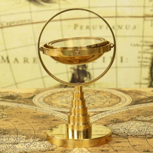 Shiny Brass Gimbal Compass-1 Shiny brass desktop gimbal compass on a tiered stand, displayed on a vintage world map.