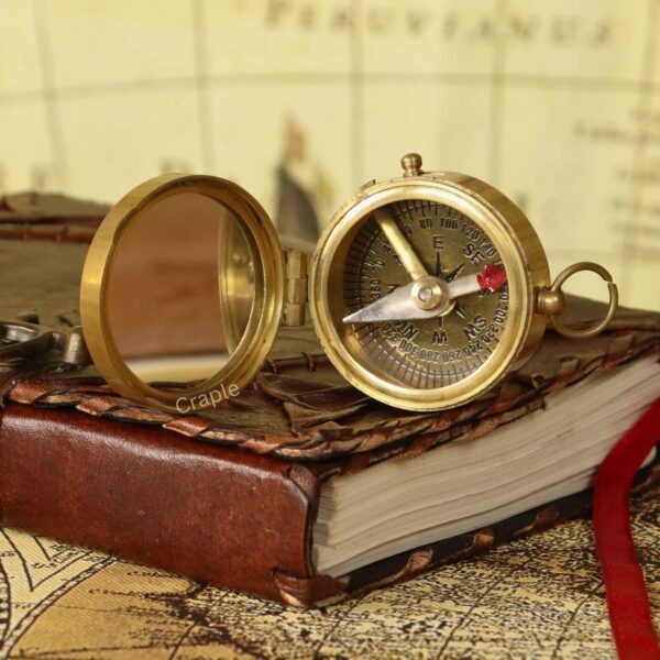 Shiny Brass Pocket Compass with Mirror-3 The shiny brass pocket compass opened at an angle to display its classic dial with cardinal points.