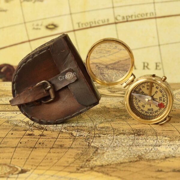 Shiny Brass Pocket Compass with Mirror-7 The open brass pocket compass displayed next to its protective, hand-stitched brown leather carrying pouch.