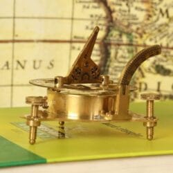 Detailed close-up of the adjustable gnomon hinge and latitude scale on the brass sundial compass.