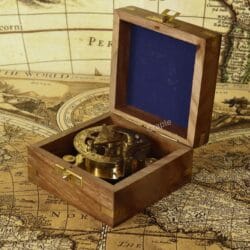 The shiny brass sundial compass nestled inside its felt-lined, handcrafted wooden storage and display box.