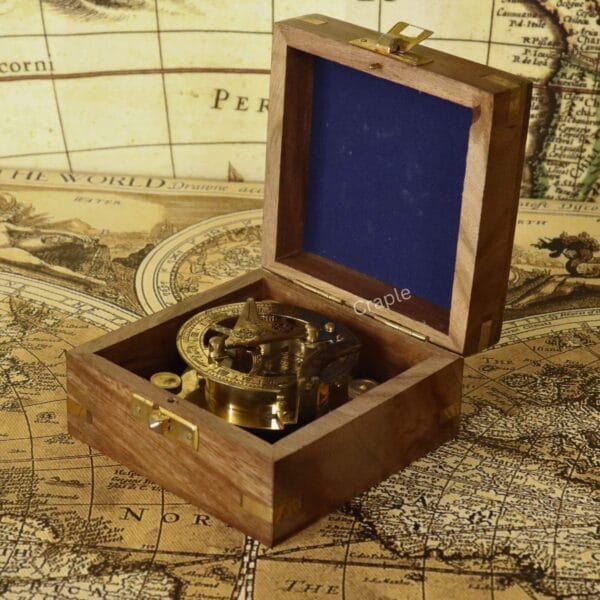 The shiny brass sundial compass nestled inside its felt-lined, handcrafted wooden storage and display box.